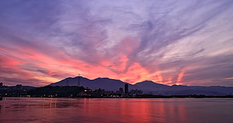 Vibrant Pink and Purple Sunset Sky Over City and Mountains