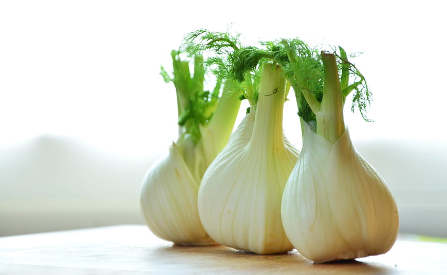 Fresh Fennel Bulbs With Green Tops On Wooden Surface