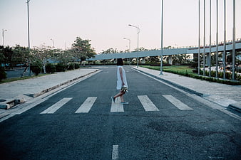 Woman in White Dress Walking Across Empty Zebra Crossing