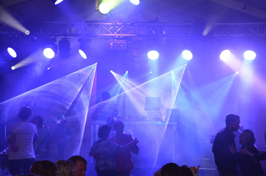 Couples dancing under blue stage lights at a nightclub
