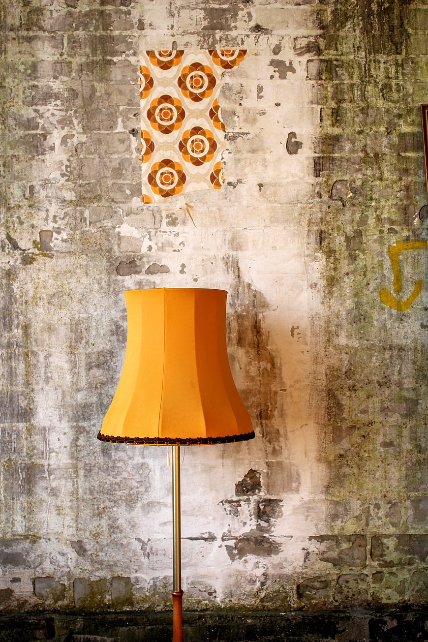 Retro Orange Floor Lamp Against Weathered Brick Wall