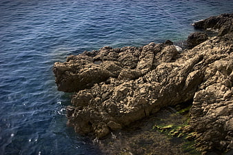 Rugged Coastal Rocks Meeting Deep Blue Ocean Water