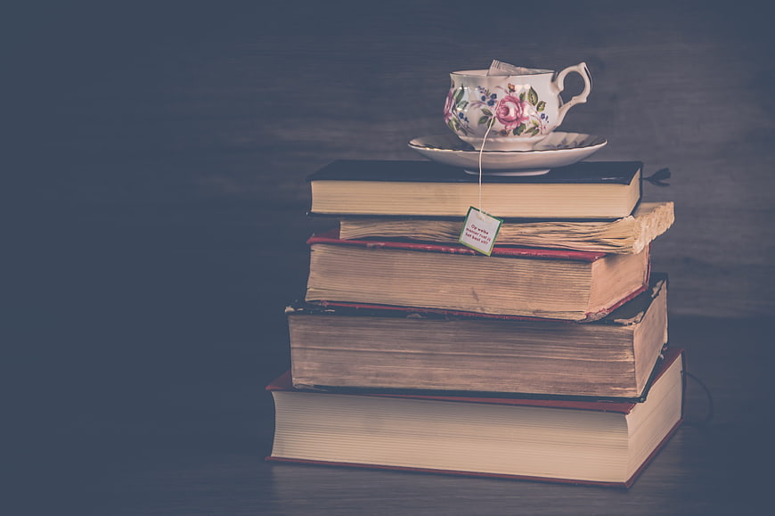 Vintage floral teacup resting on a stack of old hardcover books