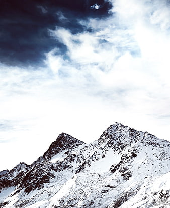Majestic Snow-Capped Mountain Peaks Under Dramatic Cloudy Sky