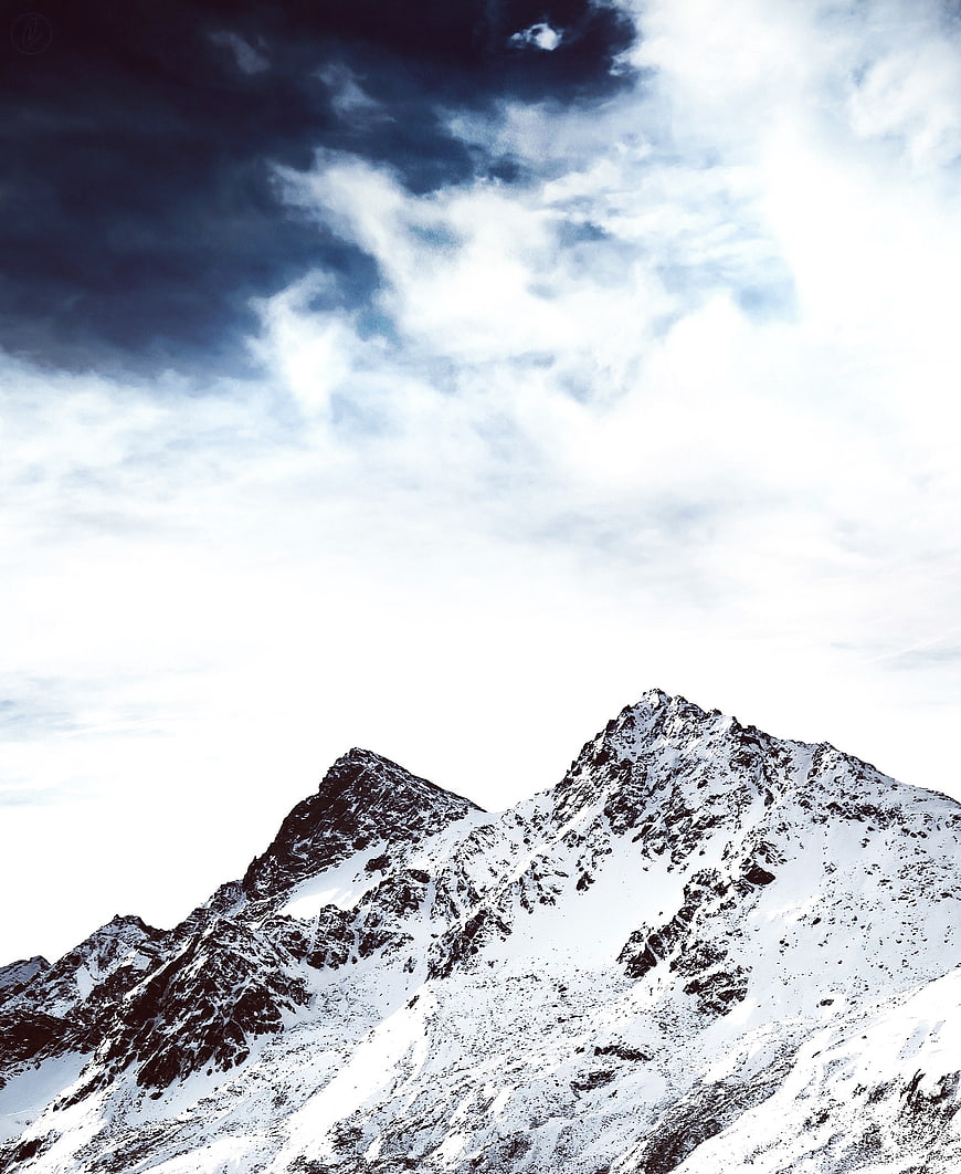 Majestic Snow-Capped Mountain Peaks Under Dramatic Cloudy Sky