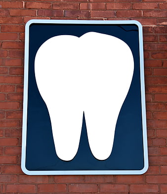 White Tooth Icon On Blue Sign Against Red Brick Wall
