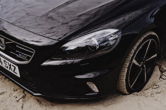 Close-up of black Volvo car stuck in sand