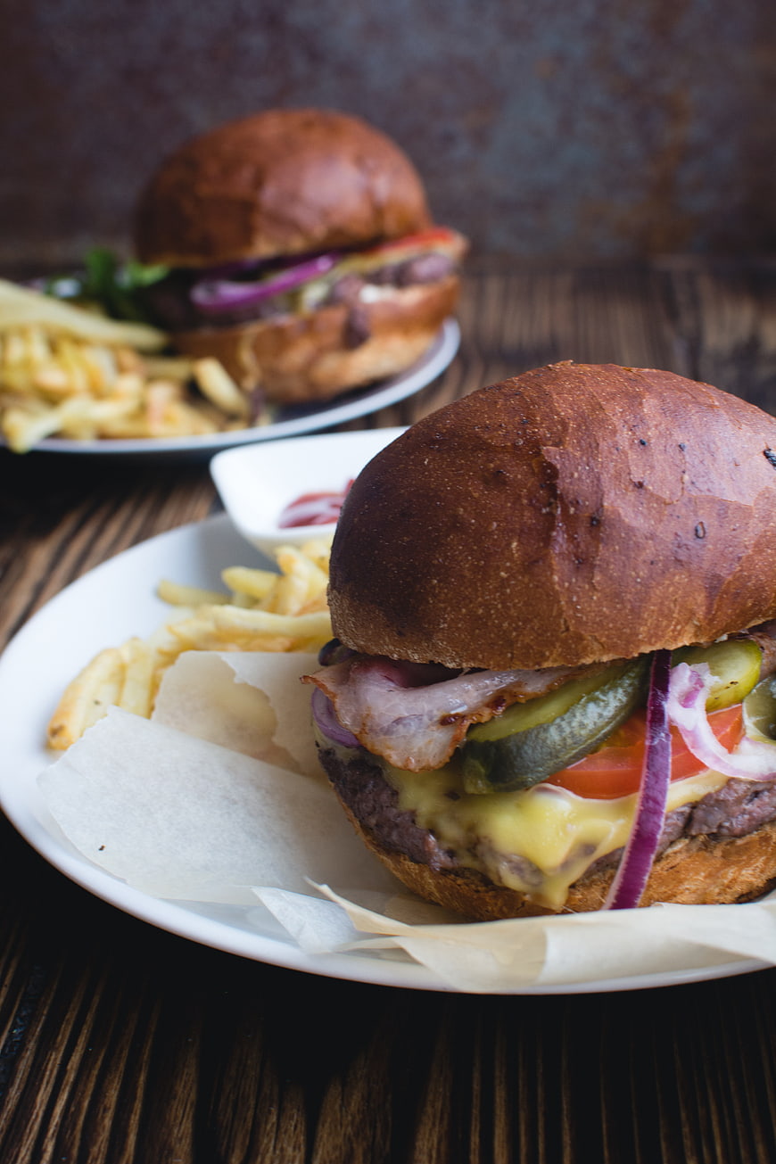 Delicious Bacon Cheeseburger with Fries on Wooden Table