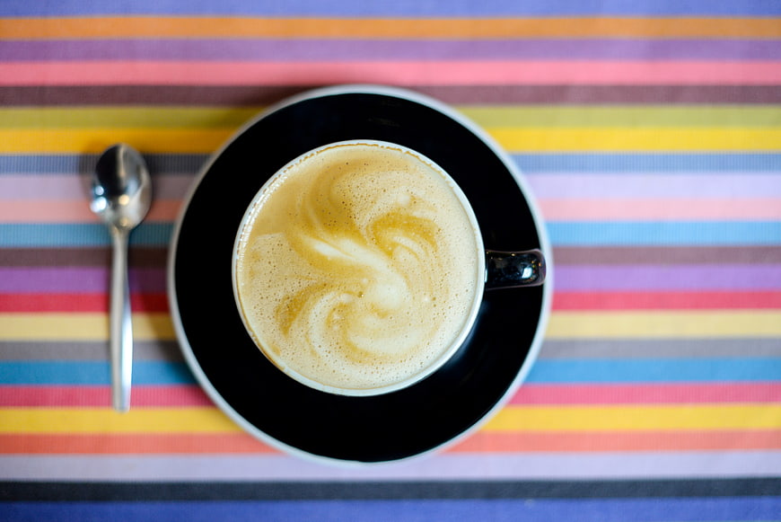 Top View of Latte Coffee on Colorful Striped Tablecloth