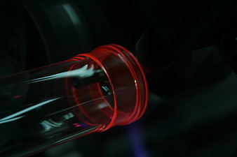 Close-up of red glass bottle neck with selective focus