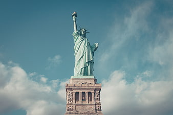 Statue of Liberty against blue sky with clouds