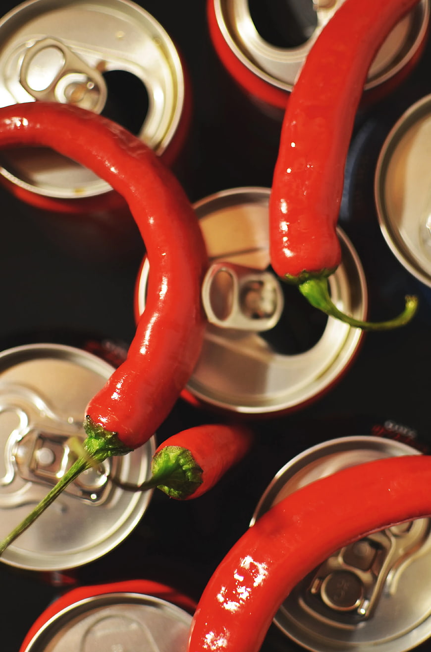 Top View of Red Chili Peppers on Open Soda Cans