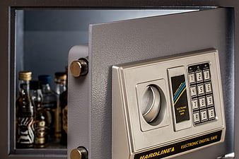 Open digital wall safe with liquor bottles inside