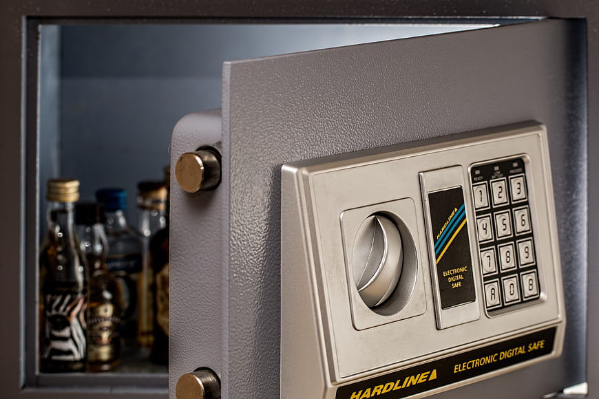 Open digital wall safe with liquor bottles inside