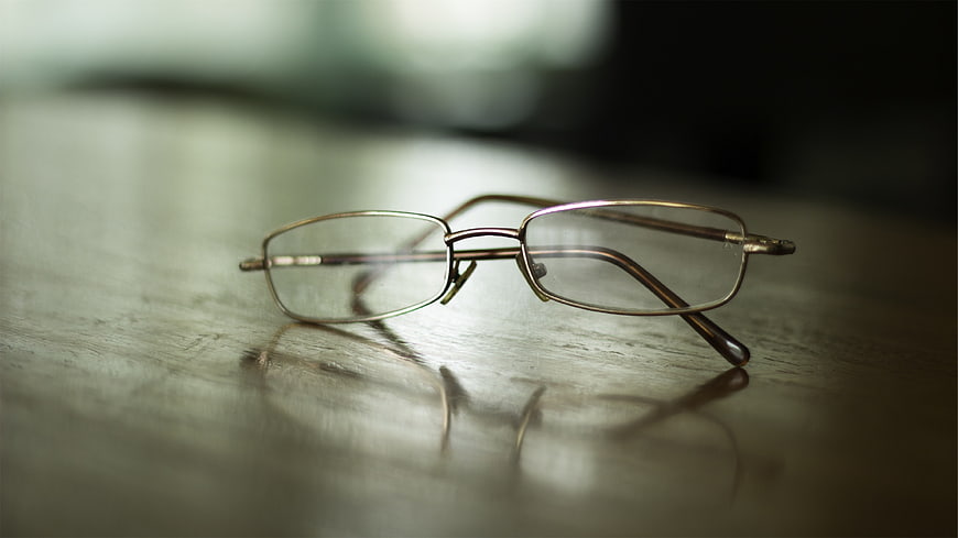 Close-up of metal eyeglasses on a wooden table