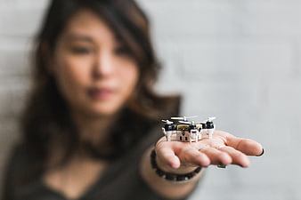 Woman holding miniature drone in palm