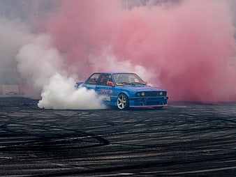 Blue BMW Drifting Car With Pink Smoke On Asphalt Track