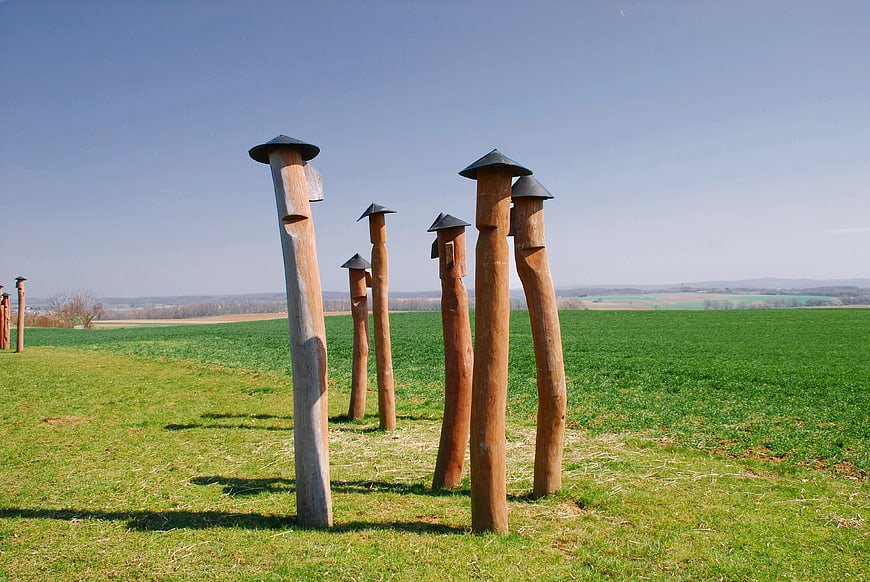Wooden birdhouses in a green field with blue sky