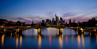 Frankfurt skyline and bridge at twilight with water reflections