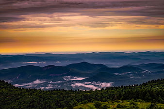 Misty Mountain Range at Sunset with Golden Sky
