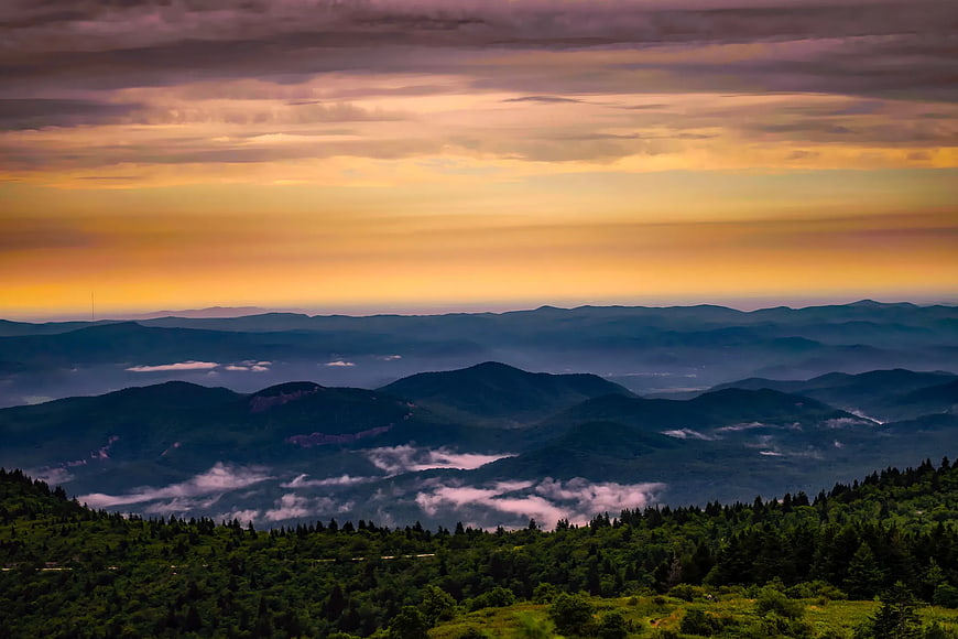 Misty Mountain Range at Sunset with Golden Sky