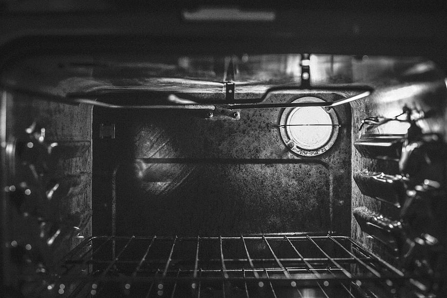Black and white interior of an empty oven with racks
