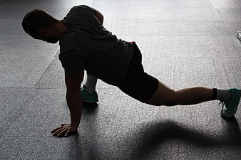 Man doing side plank exercise in gym