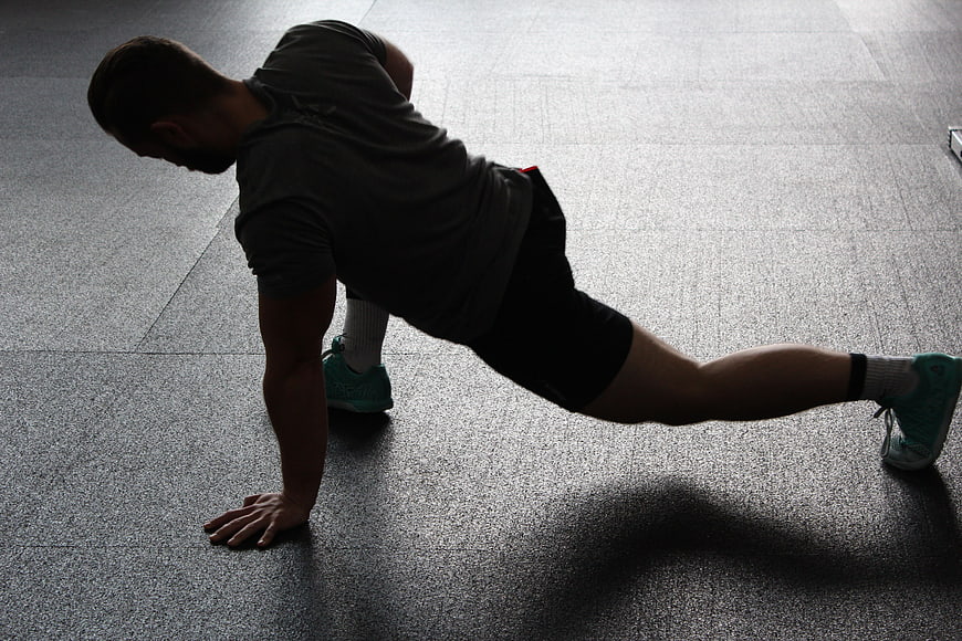 Man doing side plank exercise in gym