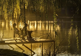 Two Anglers Fishing on a Misty Lake Pier at Golden Hour