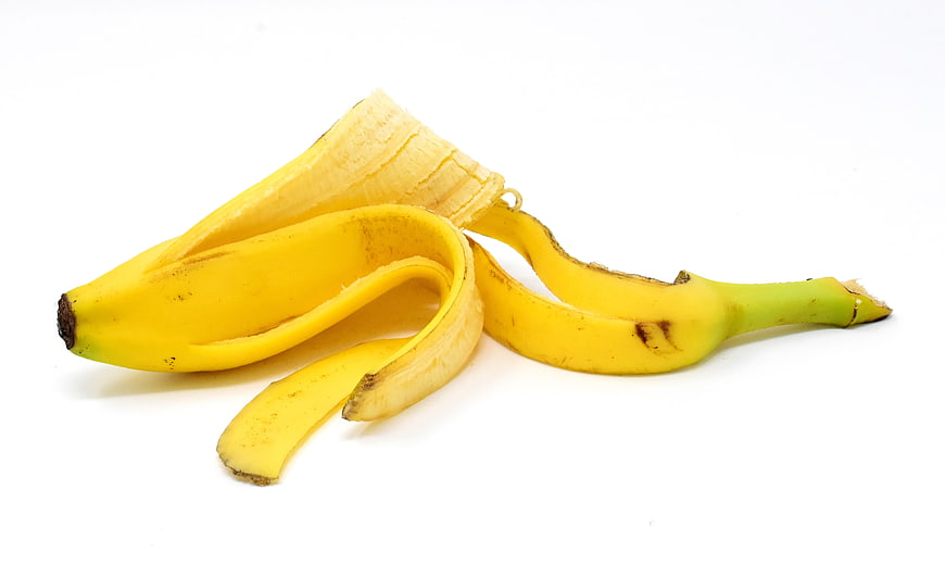 Peeled banana with yellow peel on white background