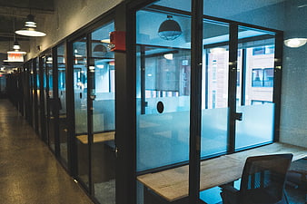 Modern office hallway with glass walls and industrial lighting