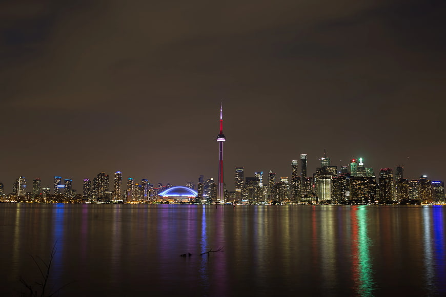 Toronto skyline at night with CN Tower and lake reflections