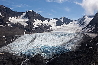 Aerial View of Majestic Glacier Flowing Through Rocky Mountains