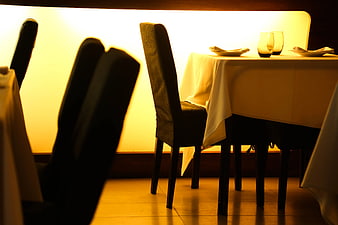 Empty restaurant table with white cloth and chairs