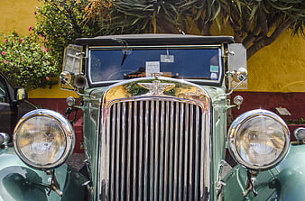 Front view of vintage green classic car with chrome grille