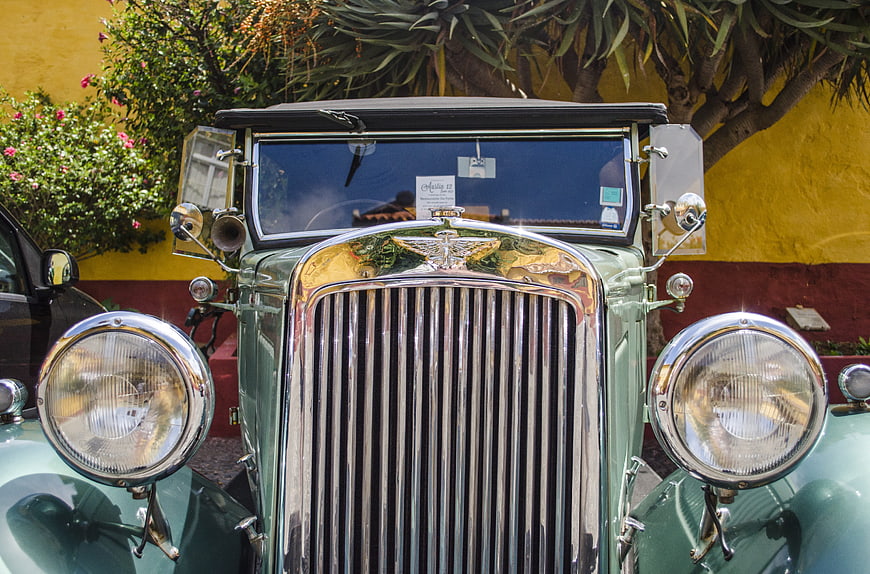 Front view of vintage green classic car with chrome grille