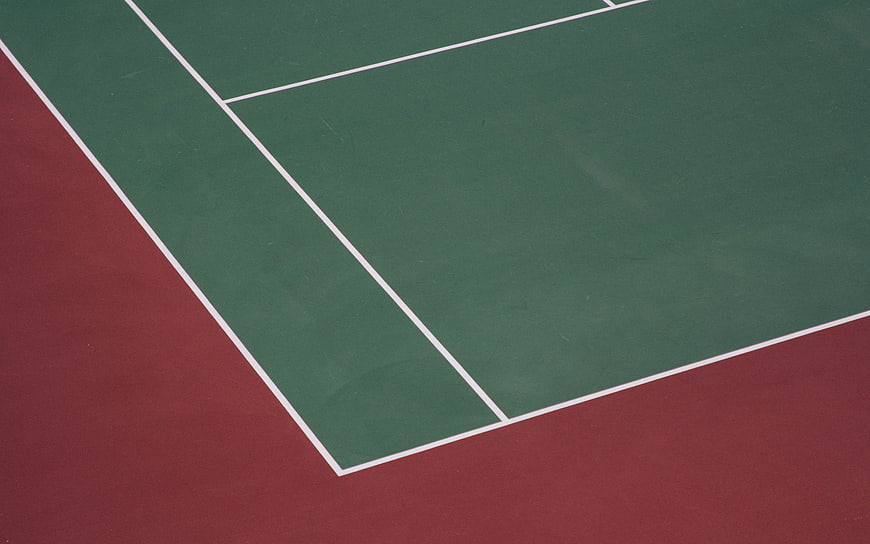 Green and red tennis court surface with white lines