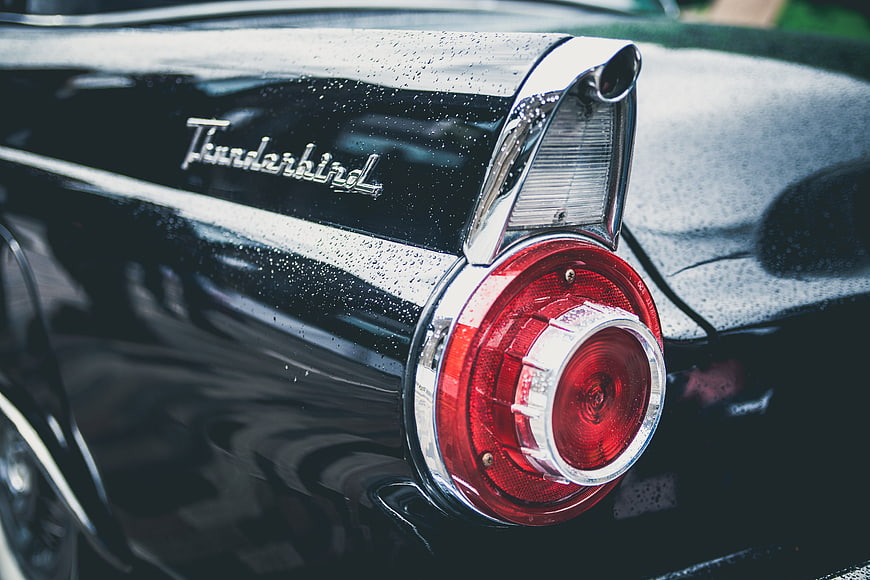 Close-up of Vintage Black Thunderbird Tail Light with Raindrops