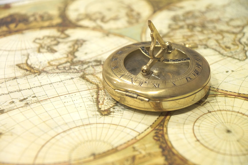 Antique brass compass resting on a vintage world map
