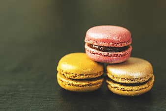 Stacked Pink and Yellow French Macarons on Dark Slate