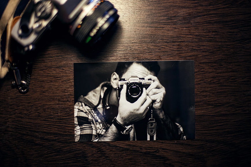 Black and white photo of photographer on wooden table