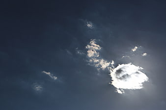 Dramatic Sunburst Through Dark Blue Clouds in Sky