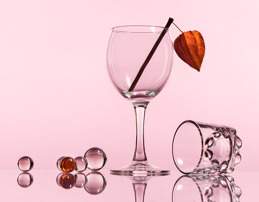Pink Still Life with Glassware, Marbles, and Dried Leaf
