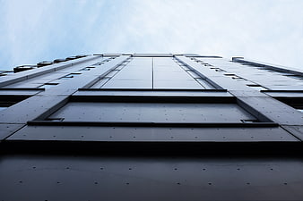 Low angle view of modern skyscraper facade against sky