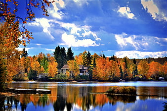 Vibrant Autumn Lake Landscape With Reflections And Cabin