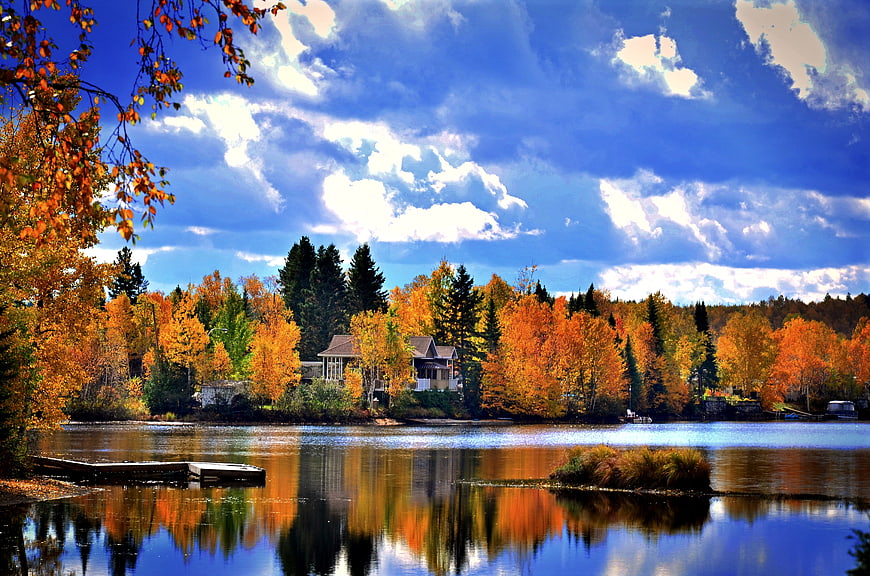 Vibrant Autumn Lake Landscape With Reflections And Cabin