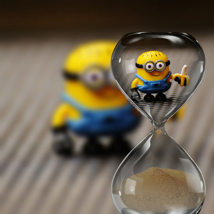 Minion toy inside hourglass with sand timer