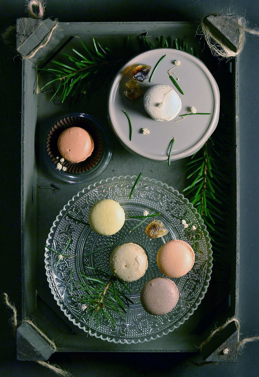 Festive macarons on vintage glass plate with pine branches