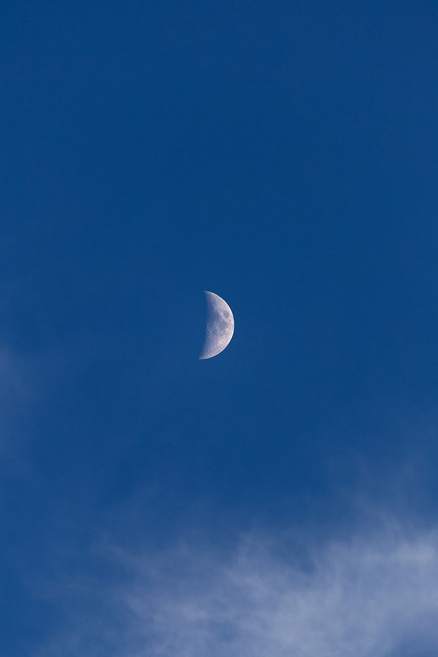 Crescent Moon in Deep Blue Sky with Wispy Clouds