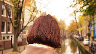 Woman with short hair looking at canal in autumn